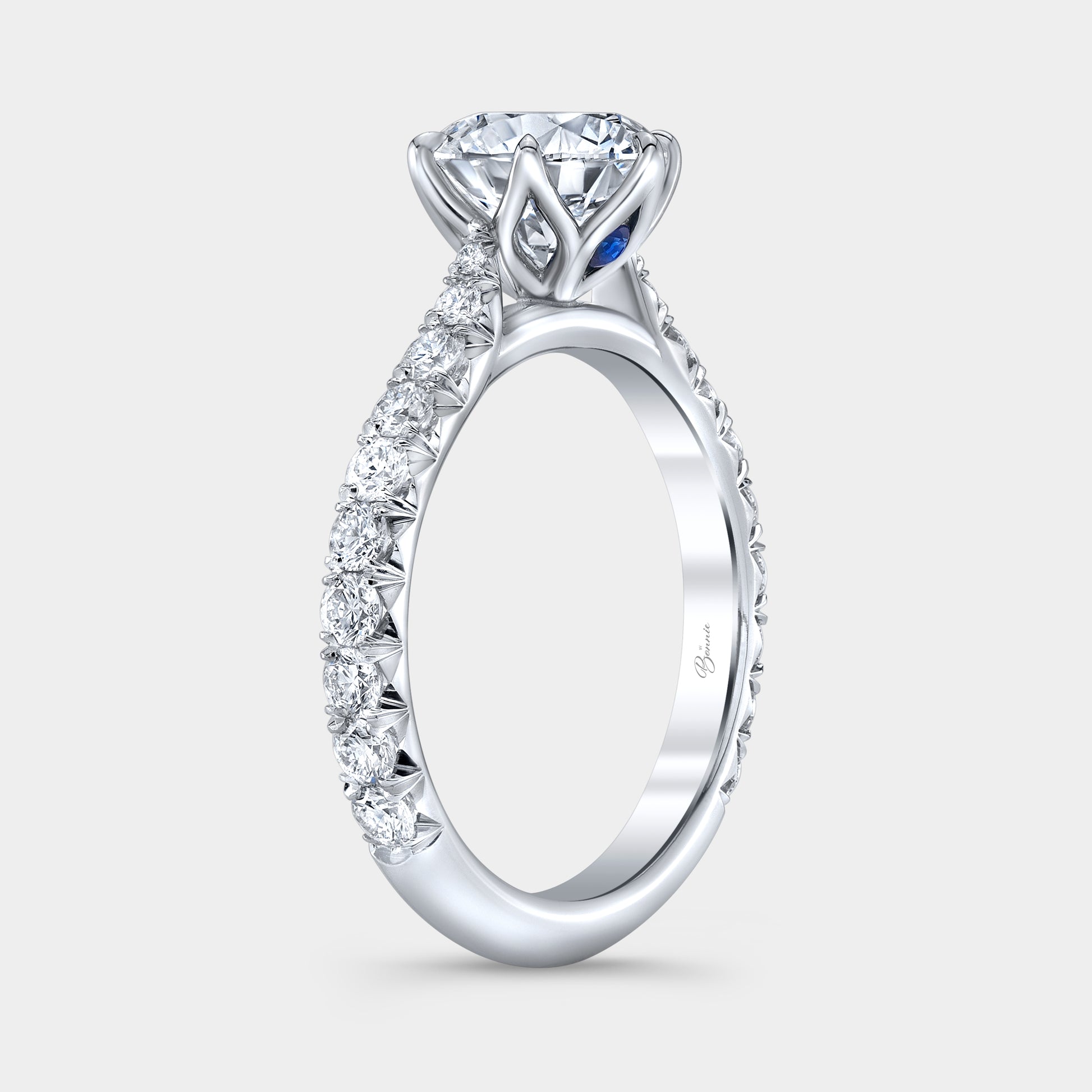 Platinum diamond ring on hand, round tulip pave.