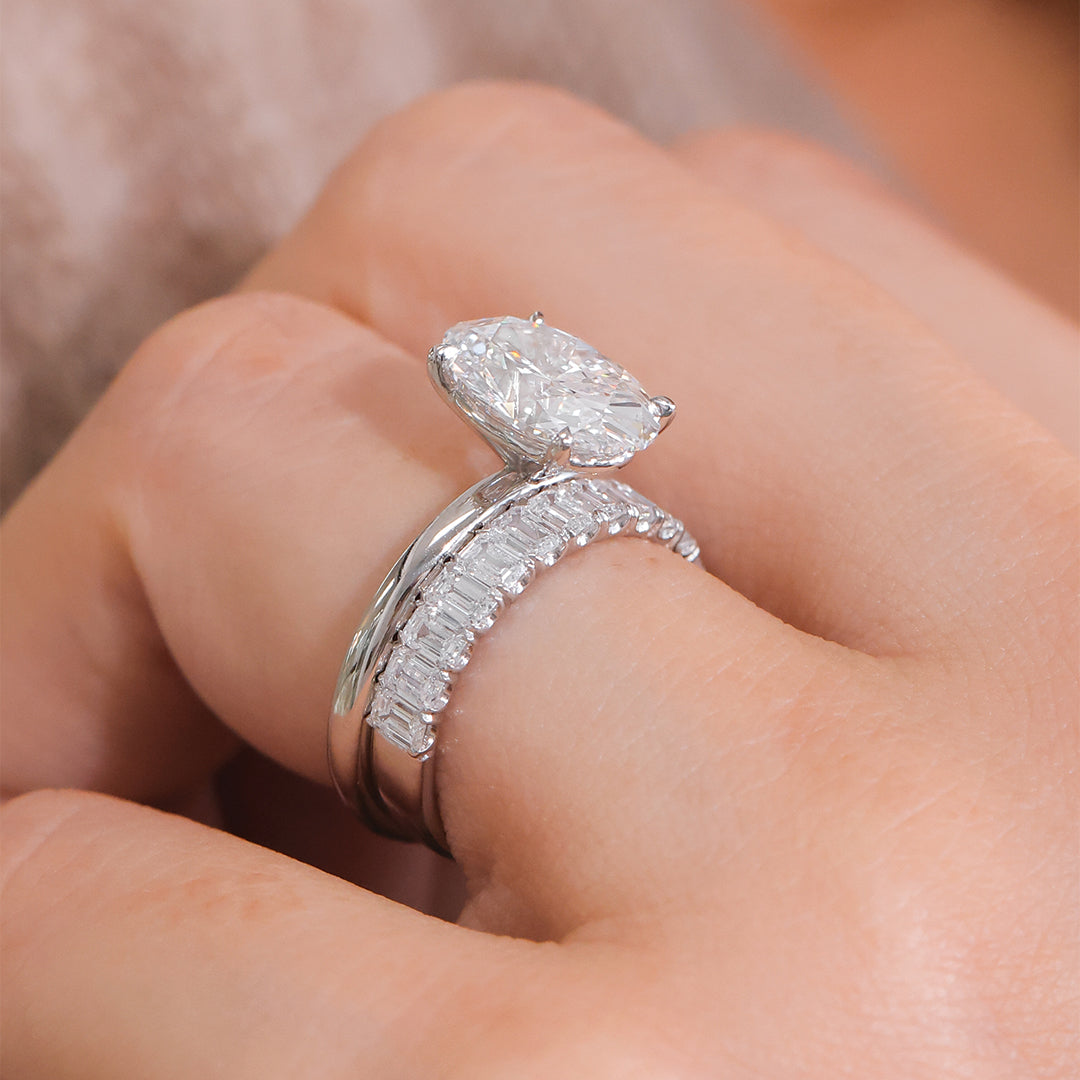 White gold emerald diamond band on hand, half way.