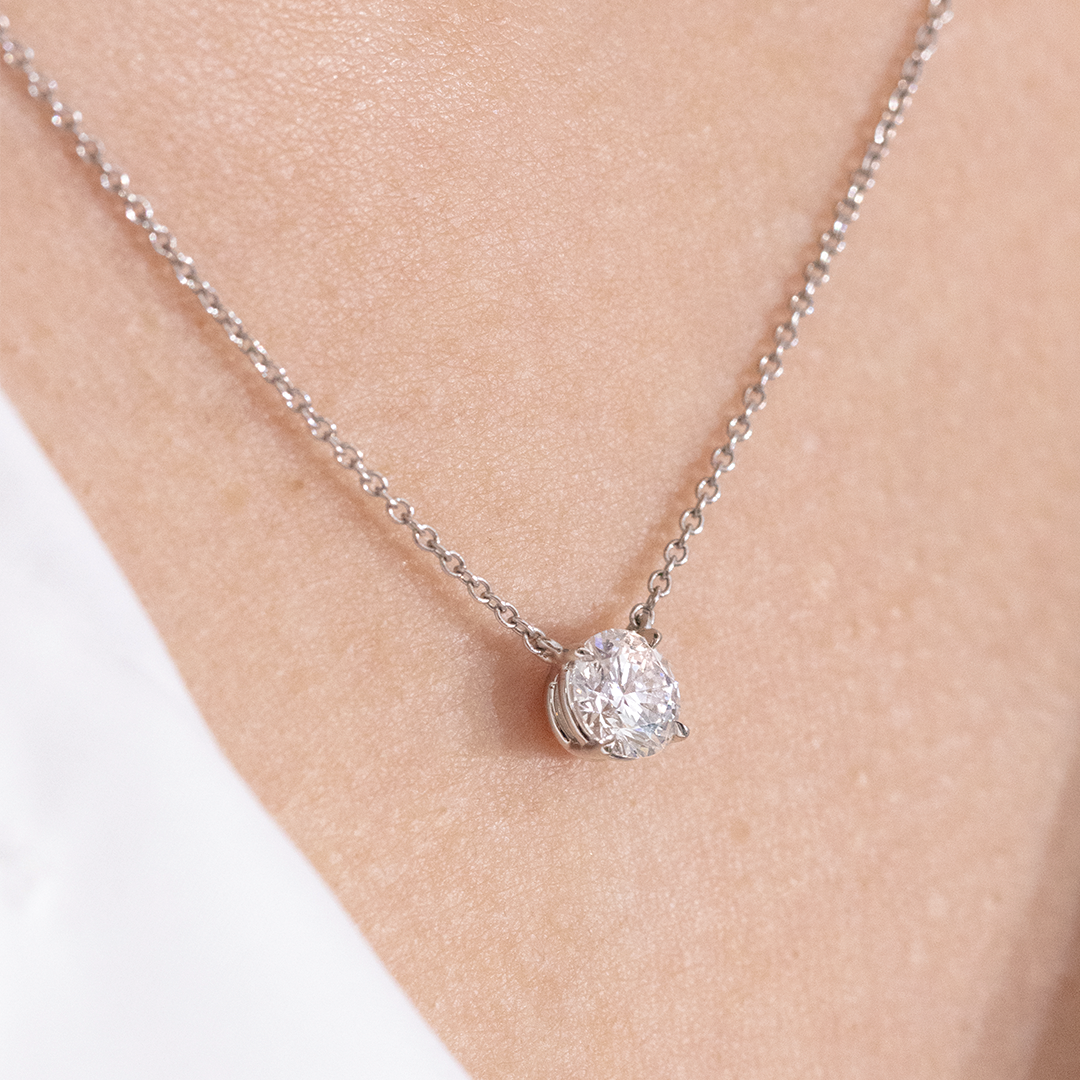 Necklace worn on person, round diamond pendant, bezel setting.