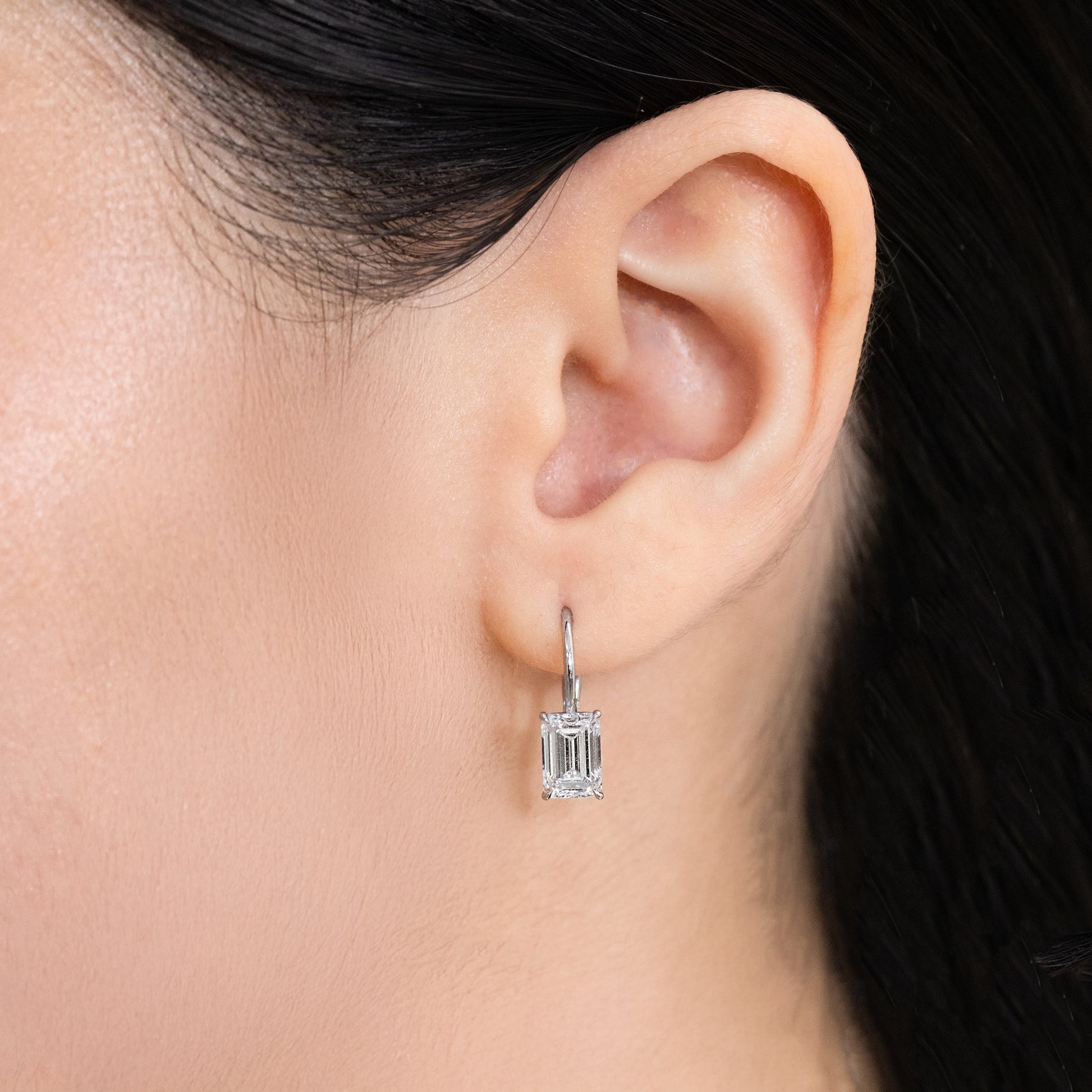 Diamond Dangle Earrings on Ear, White Gold, Emerald.