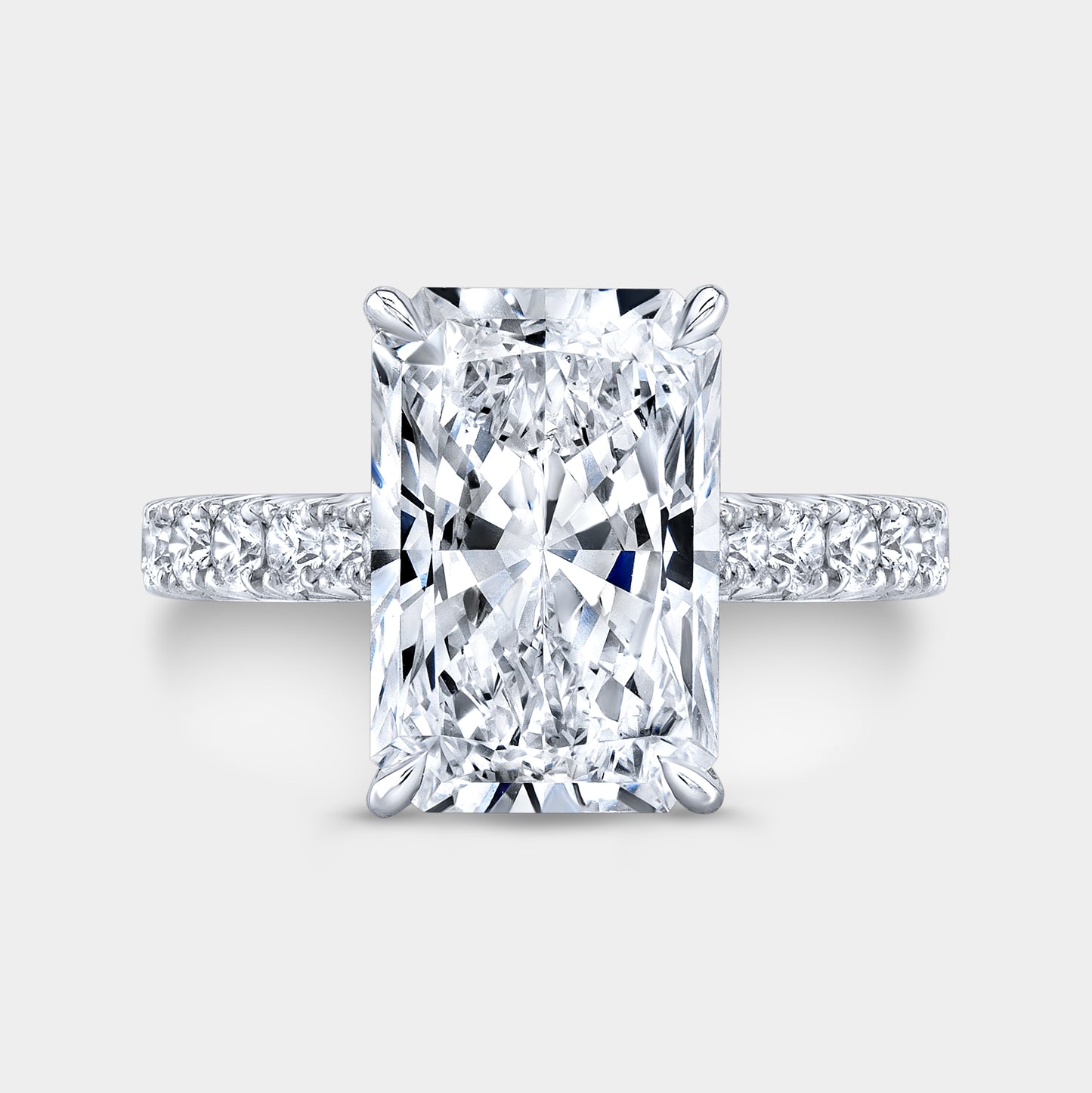 Radiant diamond halo ring, white gold band, French pave.