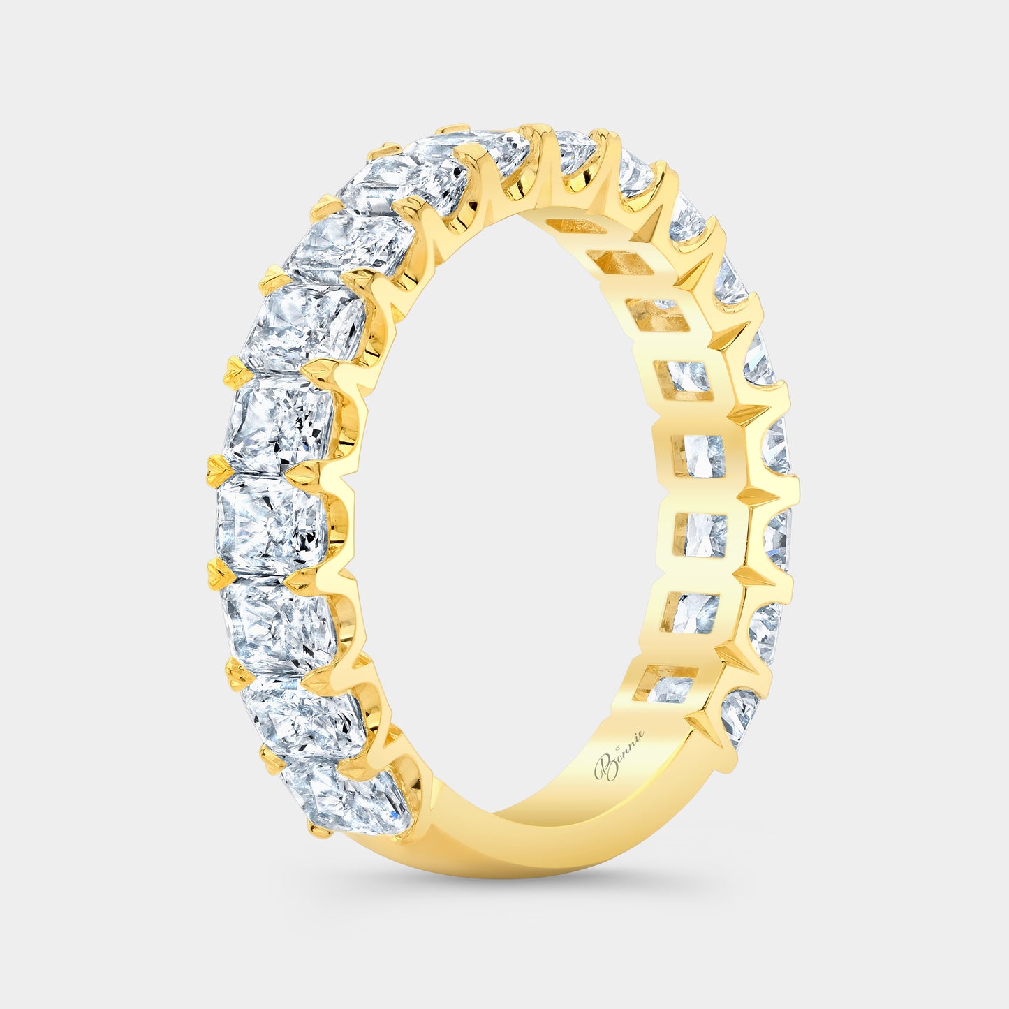 Yellow gold diamond band on hand, radiant cut.