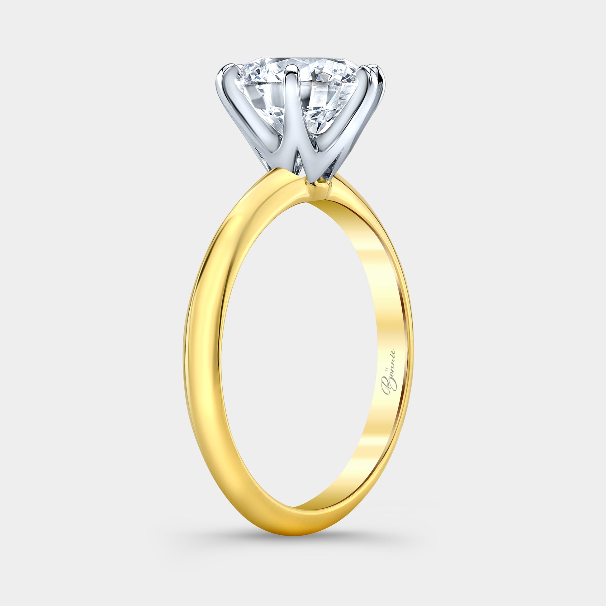 Two tone diamond ring on hand, round solitaire.