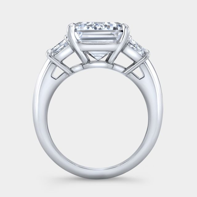 Platinum emerald diamond ring, trapezoid sides, 3 stone.