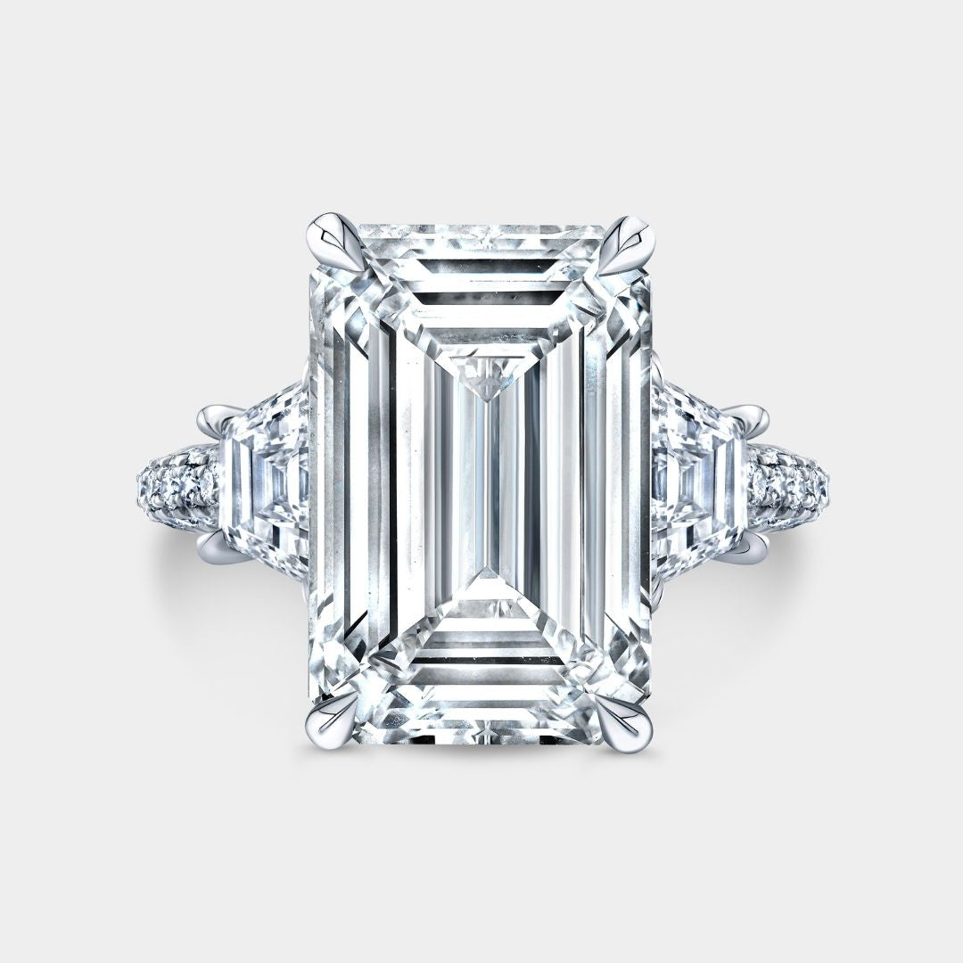 Three-stone emerald-cut diamond engagement ring with hidden halo and triple pavé in platinum