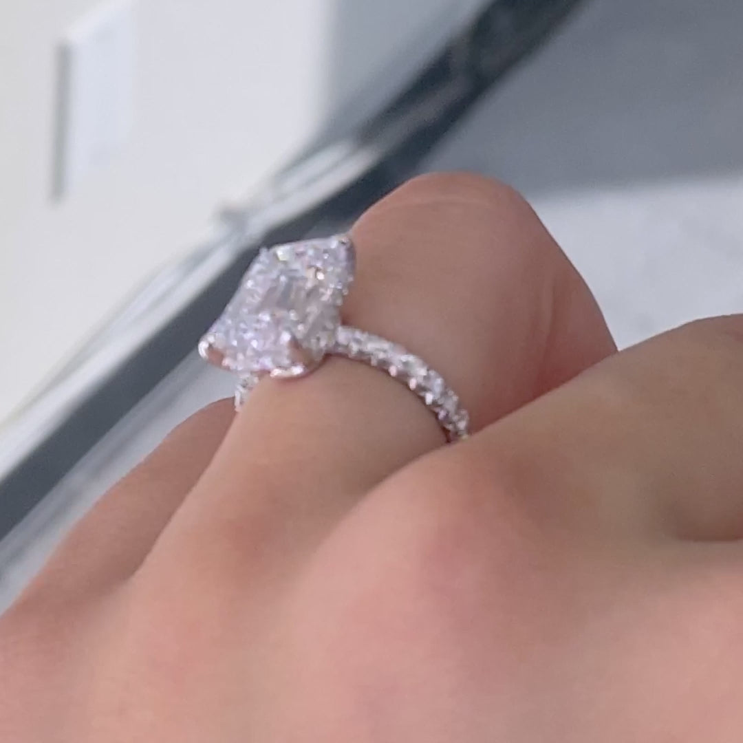 Video of a 1.5ct emerald cut diamond engagement ring with hidden halo and French pave.