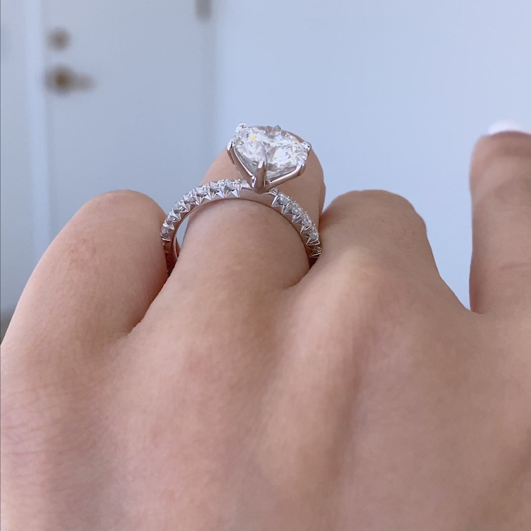 Hand with round pave platinum ring.
