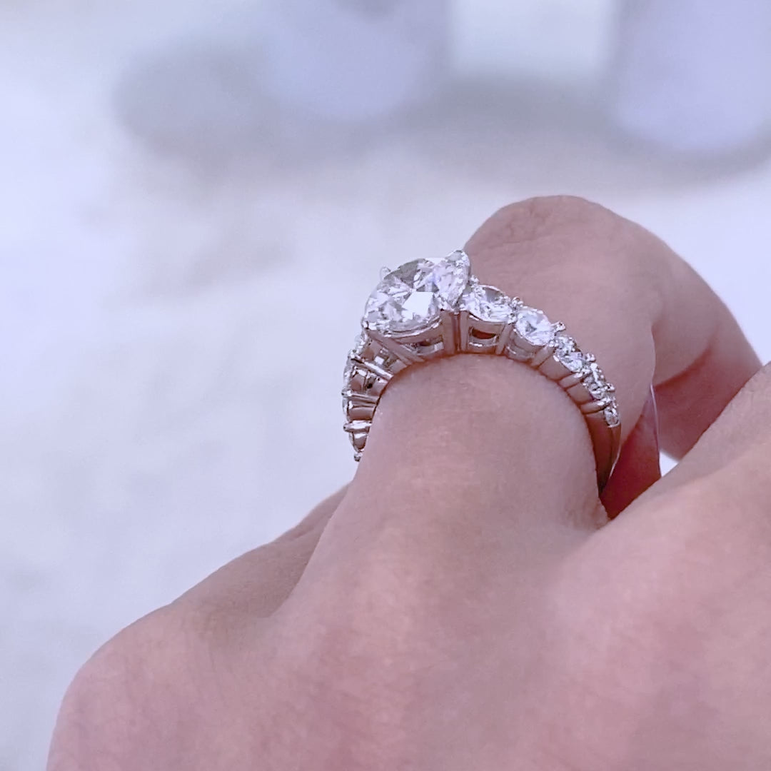 Platinum ring on hand, round diamonds.