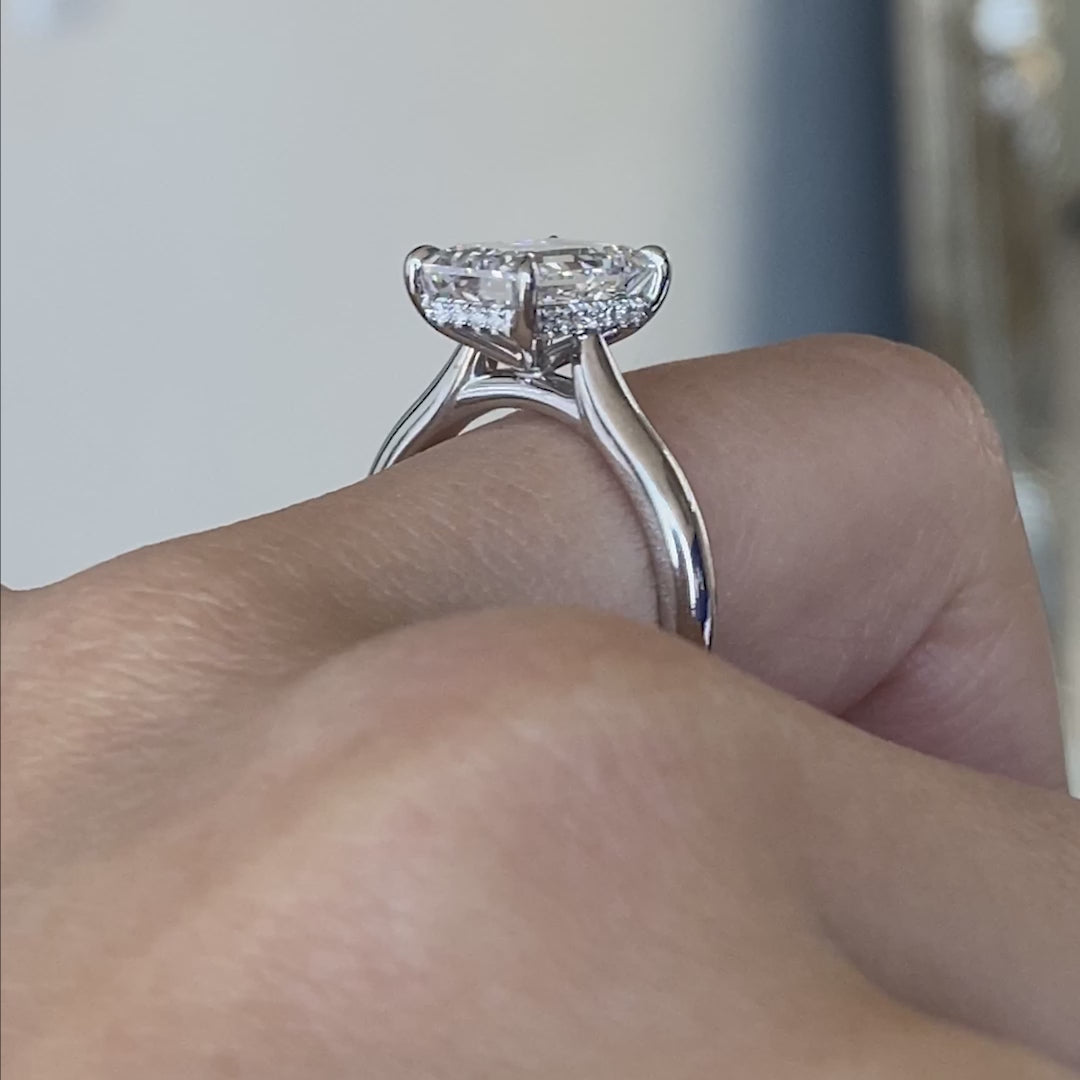 Video of a 3ct emerald diamond engagement ring with hidden halo and cathedral setting.