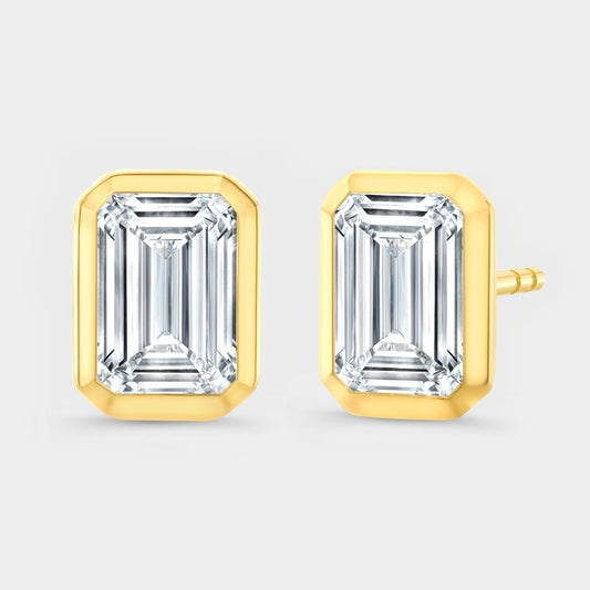Gold emerald-cut stud earrings on a light gray background