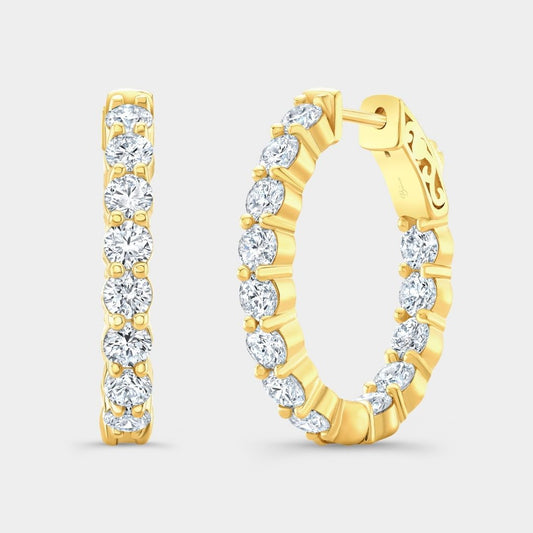 Gold hoop earrings with clear gemstones on a light gray background