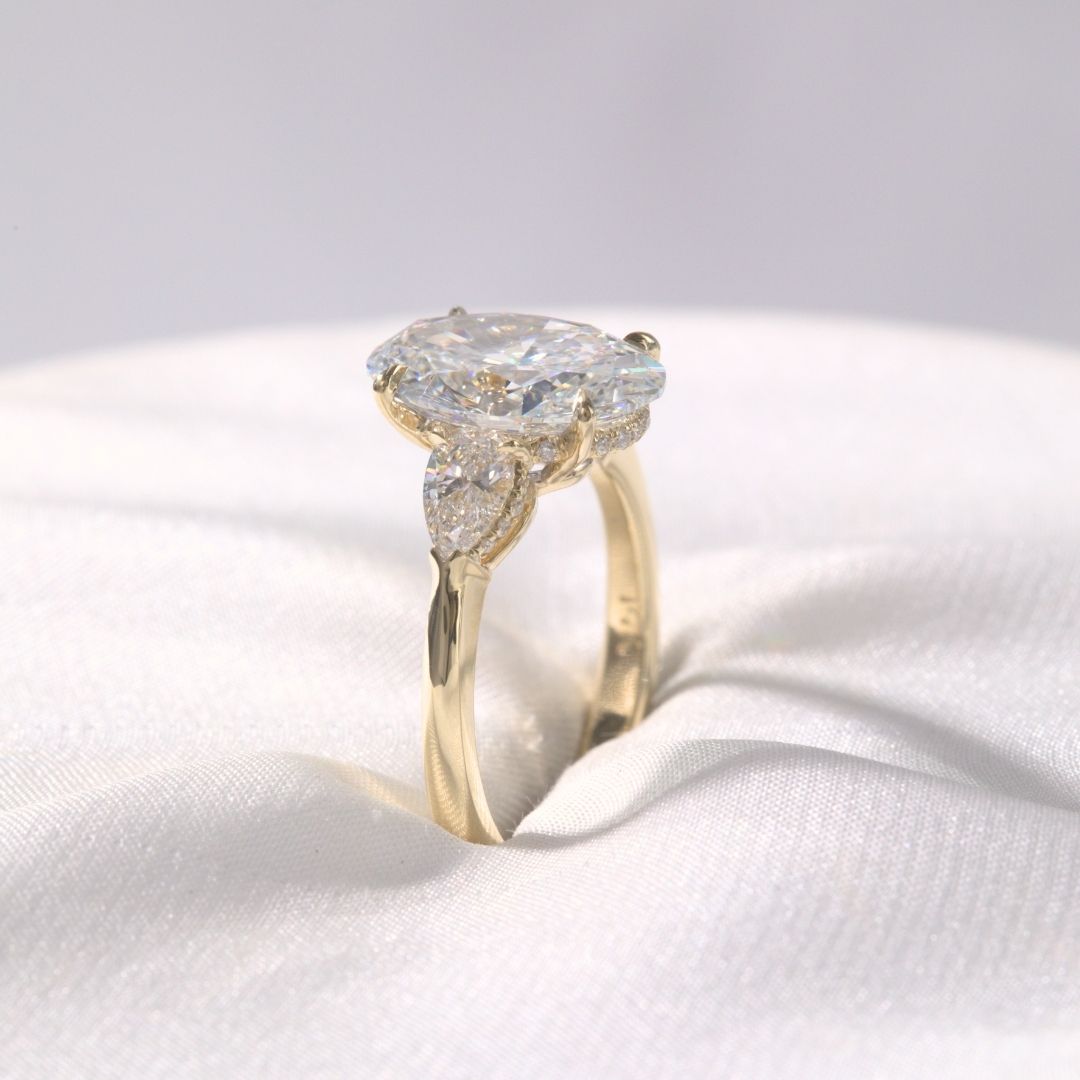 Oval Diamond Hidden Halo with Pear Shape Side Stones Yellow Gold Engagement Ring