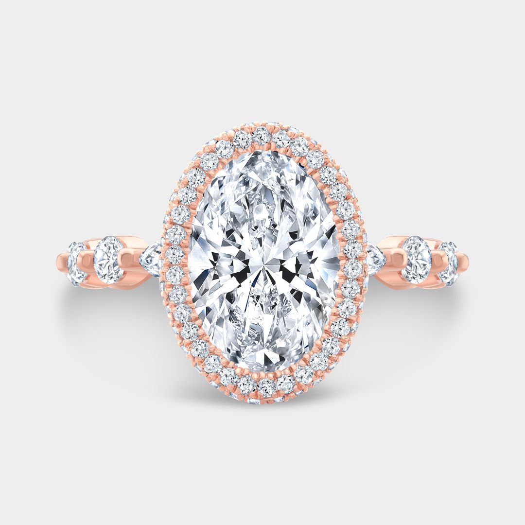 Oval diamond engagement ring with seamless halo and marquise-round accents in rose gold

