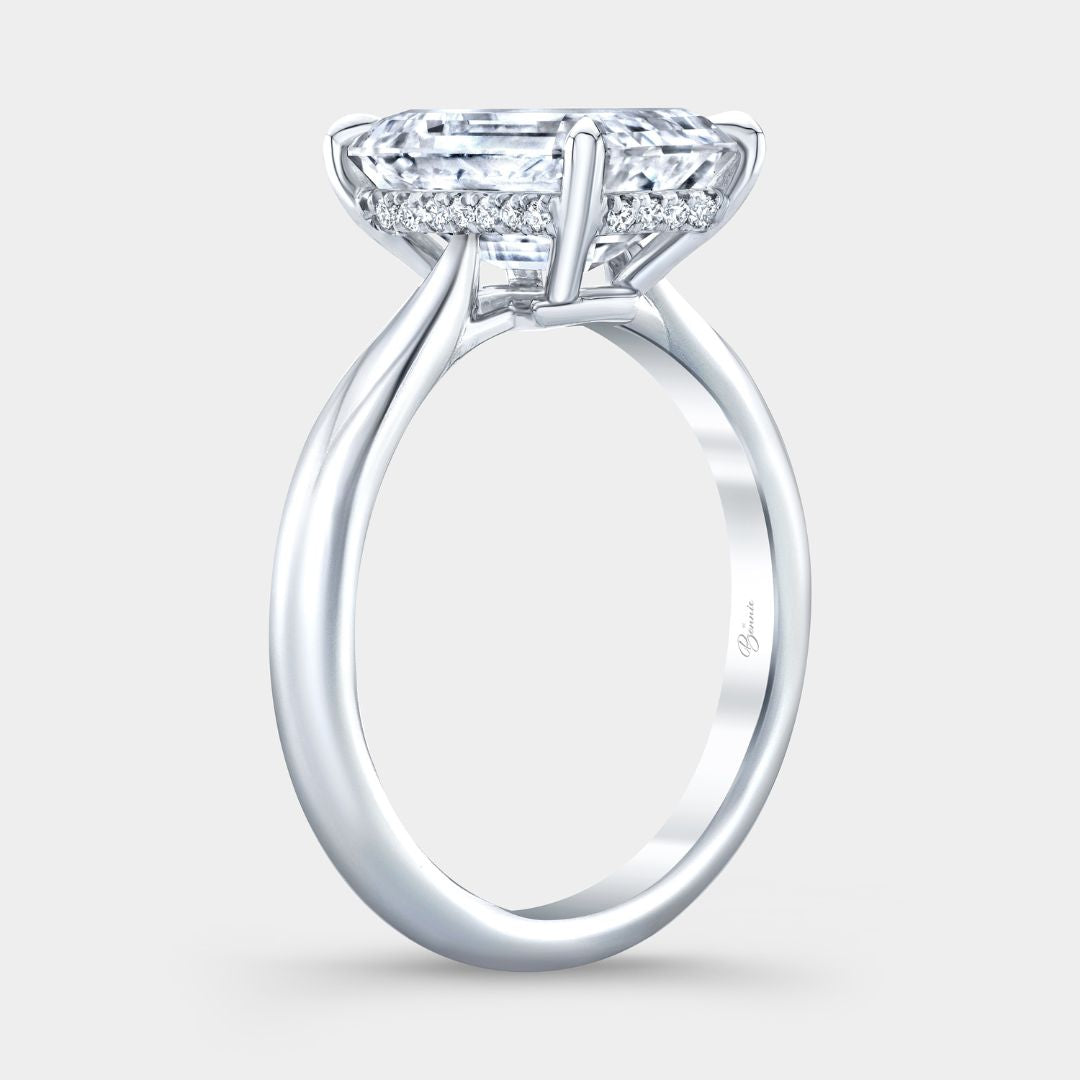 Platinum cathedral setting ring with emerald diamond and hidden halo detail
