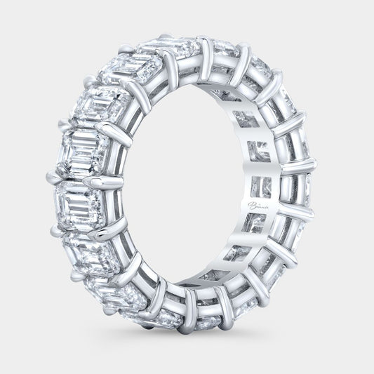 Diamond ring with emerald-cut stones on a light gray background