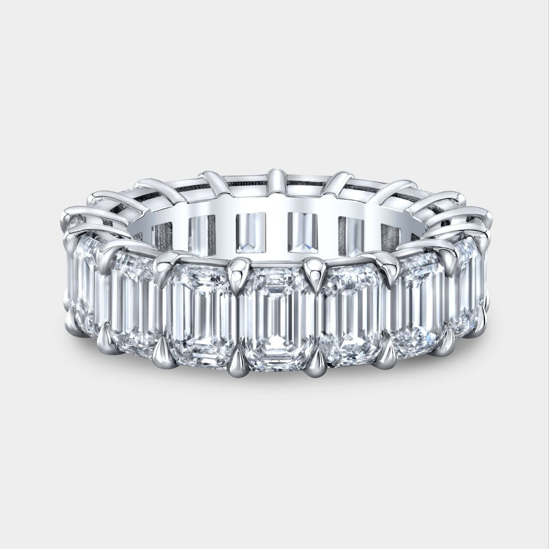 Diamond ring with emerald-cut stones on a white background