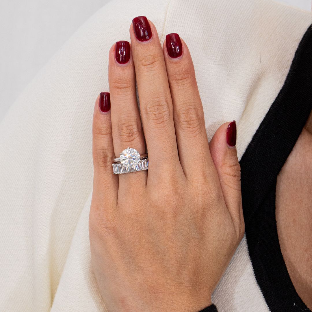 Hand with a diamond ring on a neutral background