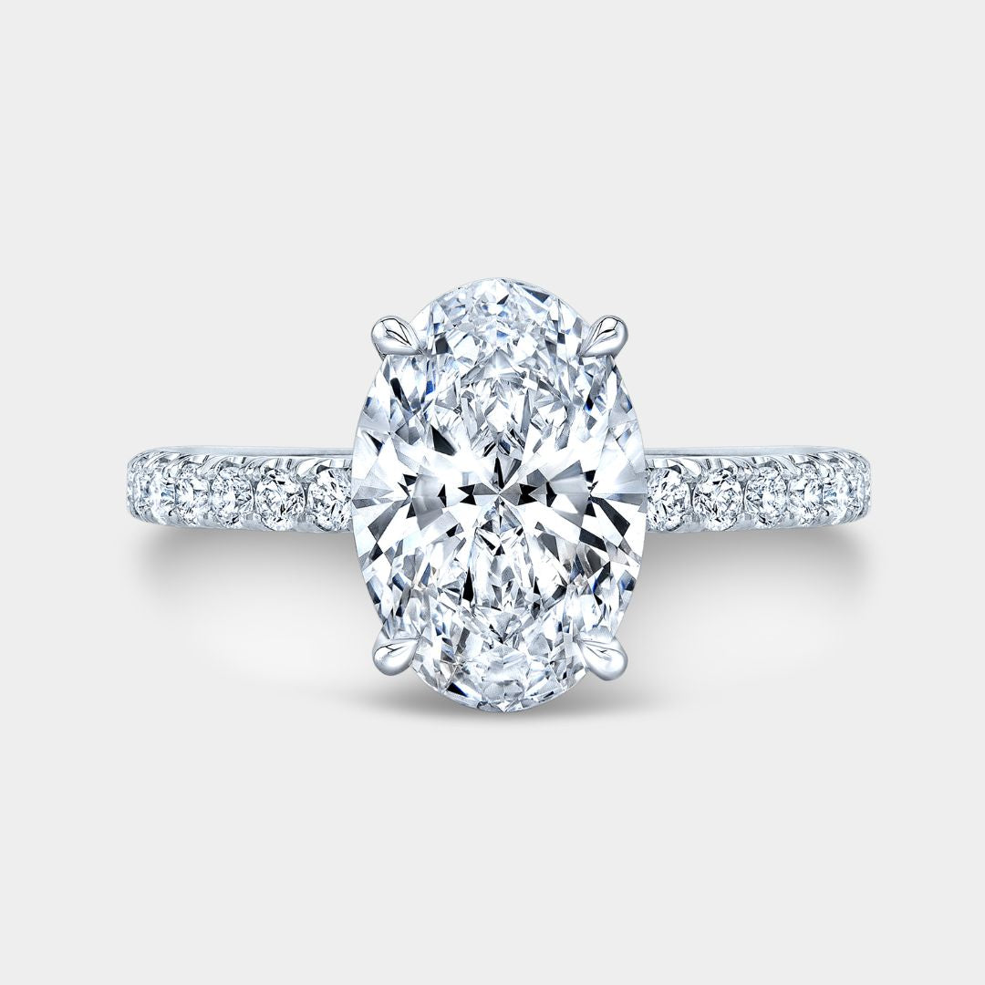 Diamond ring with a central oval-cut diamond on a light gray background