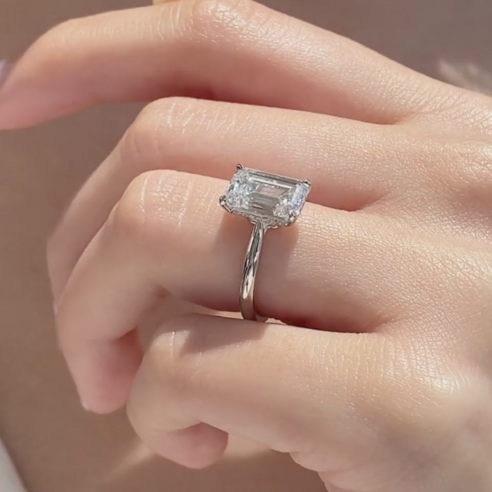 Video of platinum emerald diamond solitaire ring with hidden halo and cathedral setting
